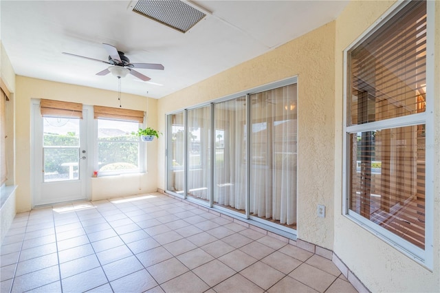 unfurnished sunroom with a ceiling fan