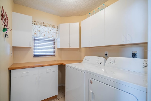 washroom featuring cabinets, a textured ceiling, light tile patterned floors, and washing machine and dryer