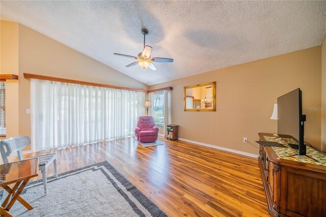 living room featuring a textured ceiling, vaulted ceiling, ceiling fan, and hardwood / wood-style flooring