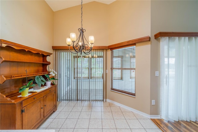 dining room with high vaulted ceiling, a notable chandelier, and light tile patterned floors