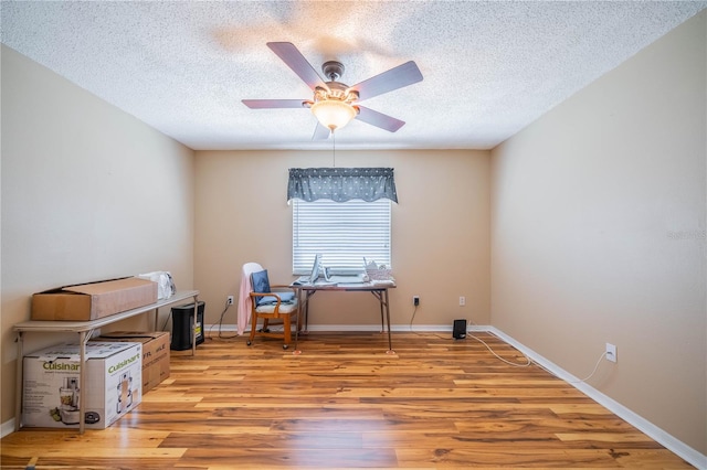 office area with ceiling fan, a textured ceiling, and light hardwood / wood-style flooring