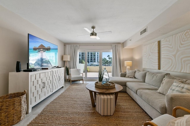 living room with ceiling fan and tile patterned flooring