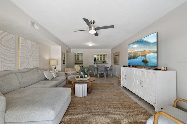 tiled living room featuring ceiling fan