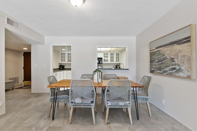 tiled dining room with a textured ceiling