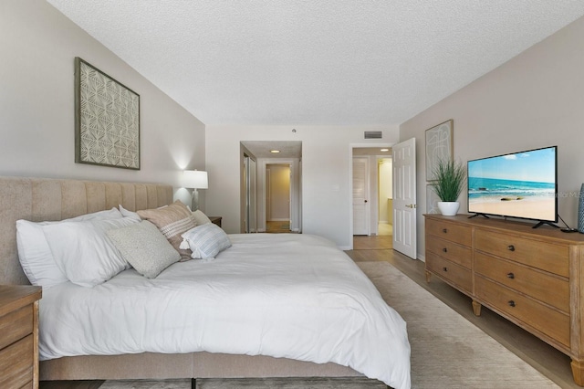 bedroom featuring light wood-type flooring and a textured ceiling