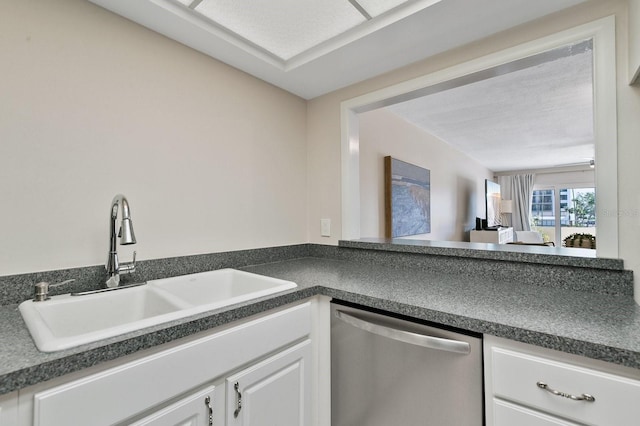 kitchen with sink, white cabinets, stainless steel dishwasher, and a textured ceiling