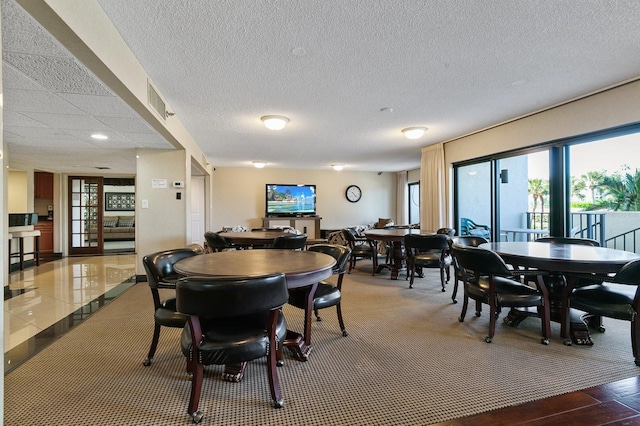 dining room with tile patterned flooring and a textured ceiling