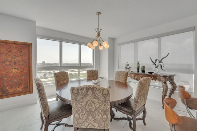 dining area featuring marble finish floor and an inviting chandelier