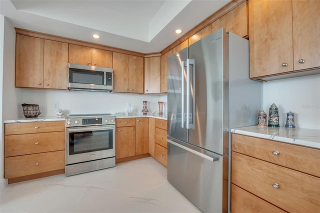 kitchen featuring brown cabinets, appliances with stainless steel finishes, light countertops, and recessed lighting