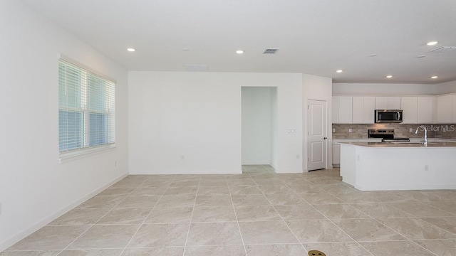 kitchen featuring white cabinetry, appliances with stainless steel finishes, and decorative backsplash