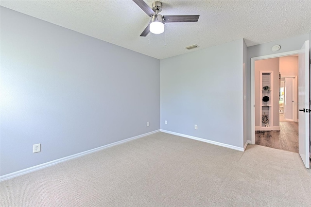 carpeted empty room with a textured ceiling and ceiling fan