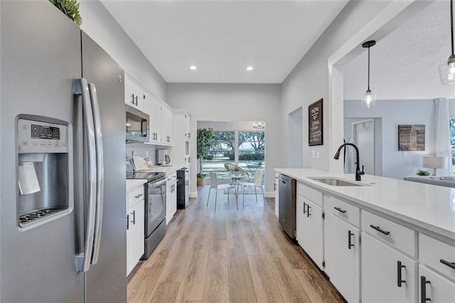 2309 Mooney Pl, Sun City Center, FL 33573 - kitchen featuring a sink, light wood finished floors, light countertops, stainless steel appliances, and white cabinetry