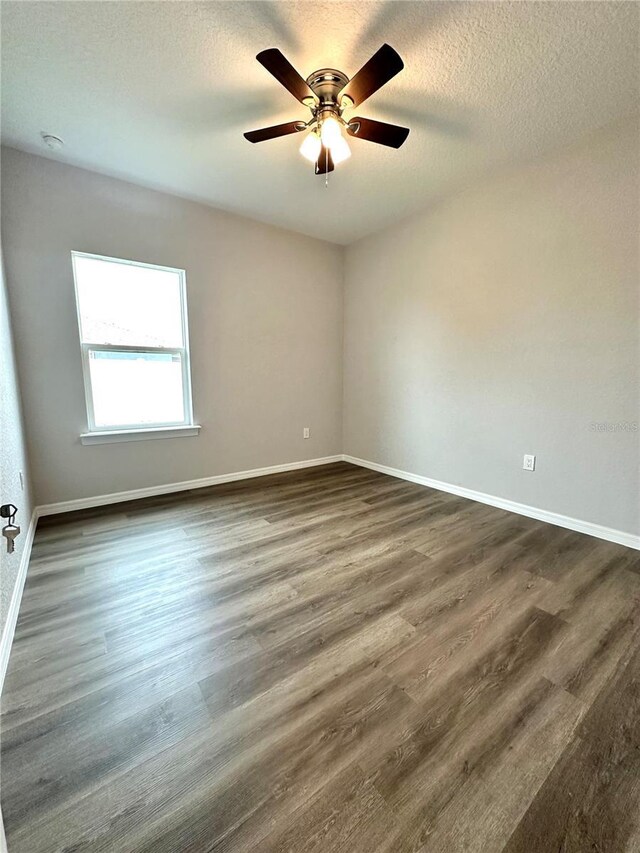 empty room featuring hardwood / wood-style flooring, a textured ceiling, and ceiling fan