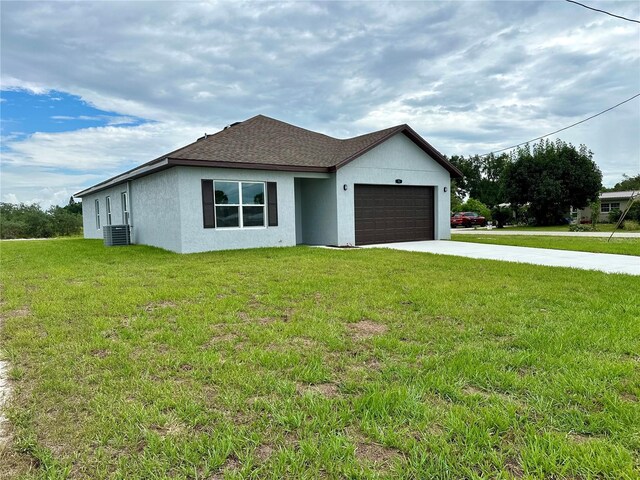 view of front facade featuring a front yard, a garage, and cooling unit