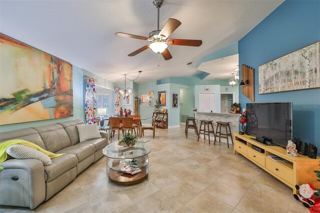 living room featuring ceiling fan with notable chandelier