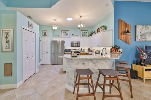 kitchen with pendant lighting, a notable chandelier, backsplash, stainless steel appliances, and kitchen peninsula