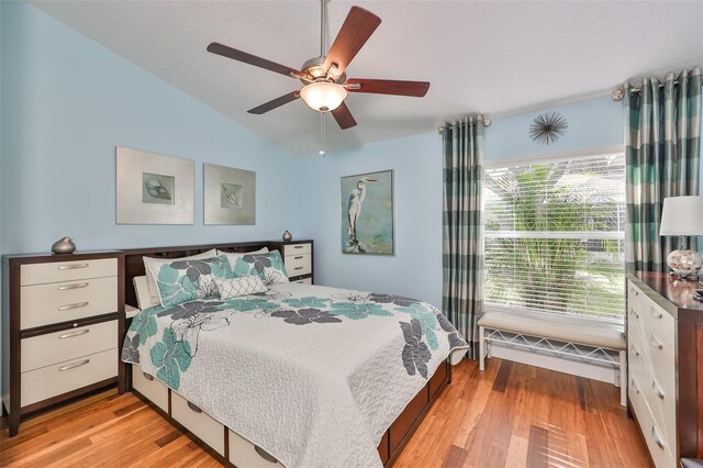 bedroom with light wood-type flooring, ceiling fan, and vaulted ceiling