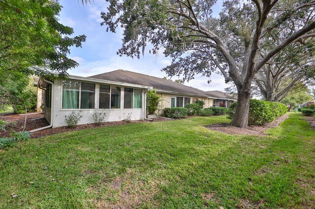 exterior space featuring a sunroom and a lawn