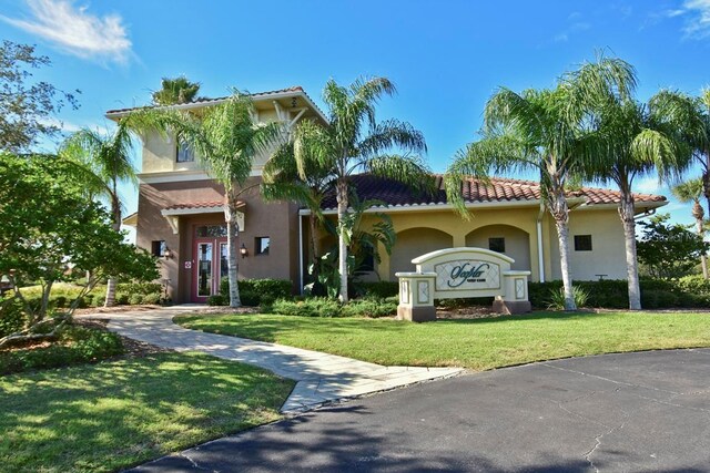 mediterranean / spanish-style home with a front lawn