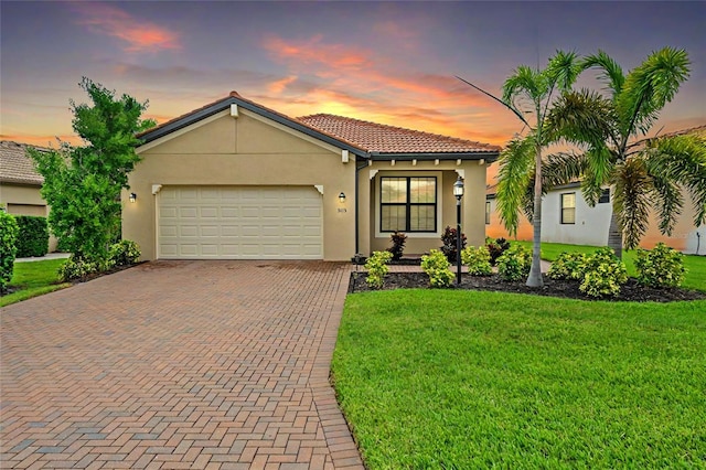 mediterranean / spanish-style house featuring a lawn and a garage