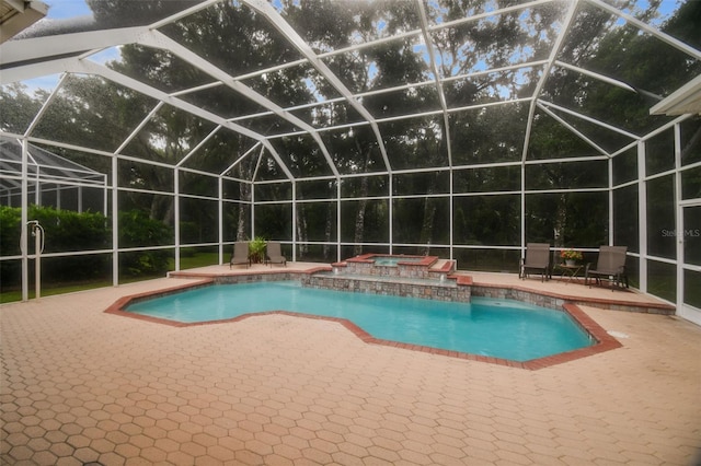 view of swimming pool featuring glass enclosure, a patio area, and an in ground hot tub