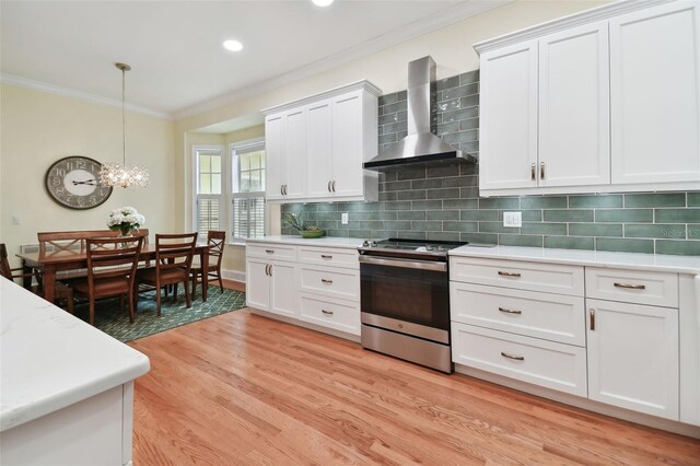 kitchen featuring wall chimney exhaust hood, decorative backsplash, light hardwood / wood-style flooring, and stainless steel range with electric cooktop