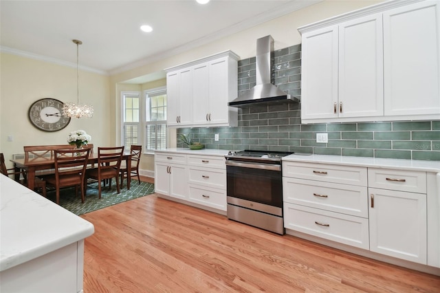 kitchen with white cabinets, wall chimney range hood, stainless steel range with electric stovetop, and light countertops