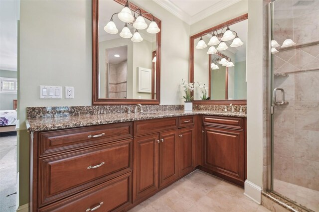 bathroom with tile patterned floors, ornamental molding, vanity, and a shower with shower door