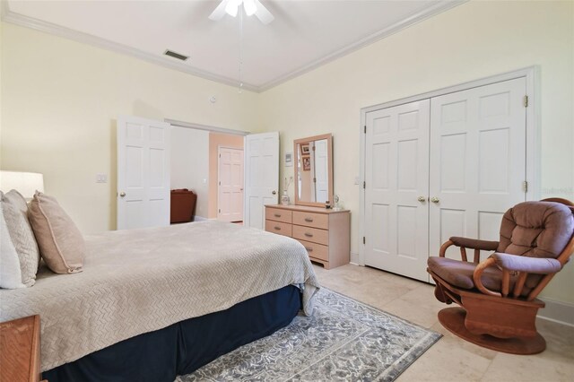 tiled bedroom with a closet, ceiling fan, and crown molding