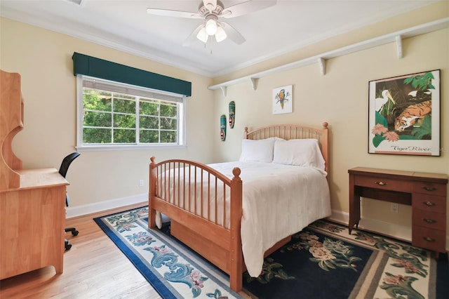 bedroom with light wood-type flooring, baseboards, ornamental molding, and ceiling fan