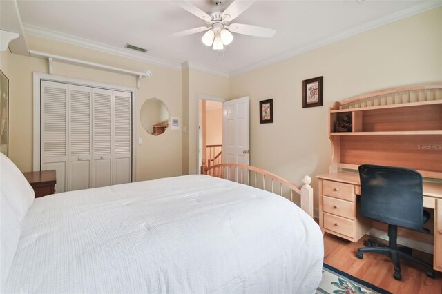 bedroom with ceiling fan, a closet, ornamental molding, and wood-type flooring