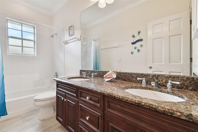 full bathroom with double vanity, ornamental molding, a sink, and toilet