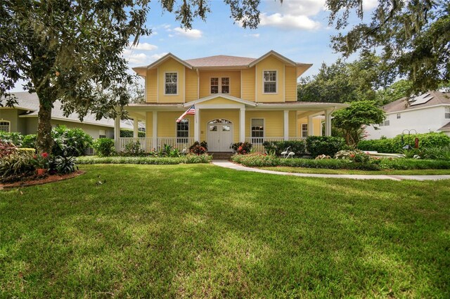 view of front of home featuring covered porch and a front yard