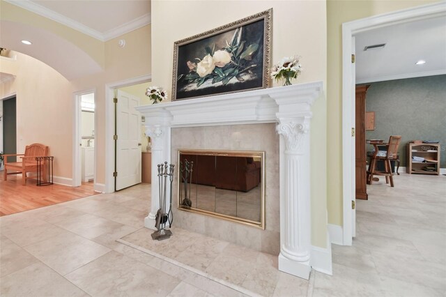 living room with ornate columns, hardwood / wood-style floors, a premium fireplace, and ornamental molding