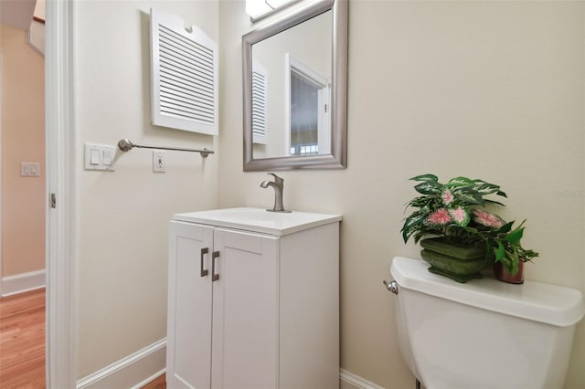 bathroom with hardwood / wood-style flooring, vanity, and toilet