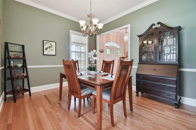 dining room featuring an inviting chandelier, light hardwood / wood-style floors, and ornamental molding