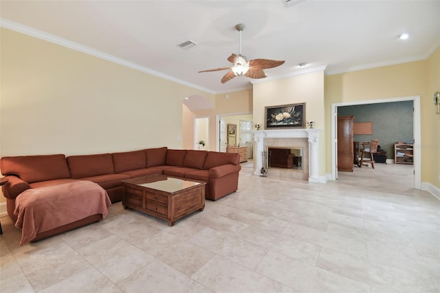 living room with a ceiling fan, baseboards, a high end fireplace, visible vents, and crown molding