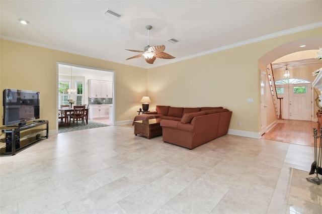 living room featuring ornamental molding, arched walkways, and visible vents