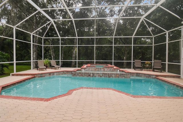 outdoor pool with an in ground hot tub, a patio area, and a lanai