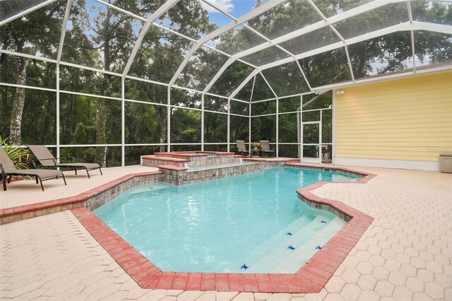 view of swimming pool featuring a lanai, a patio area, and a pool with connected hot tub