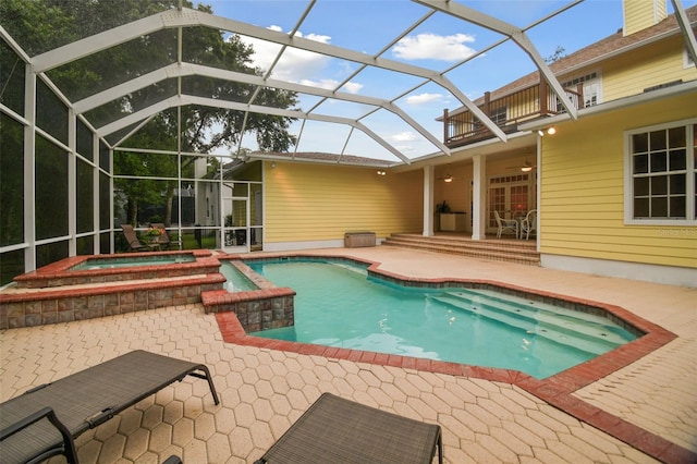 view of pool with ceiling fan, a patio, a lanai, and a pool with connected hot tub