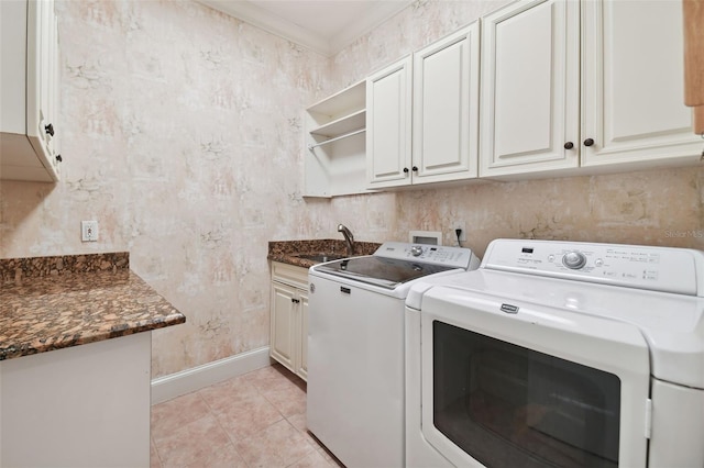 clothes washing area featuring washing machine and clothes dryer, light tile patterned floors, cabinet space, a sink, and baseboards