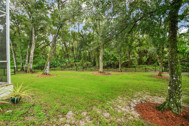 view of yard with a fenced backyard and a lanai