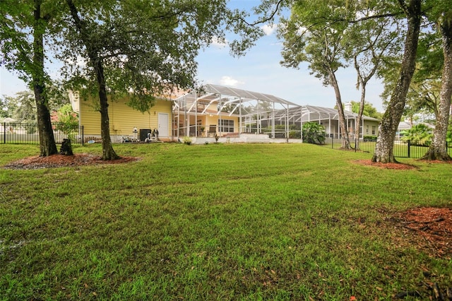 view of yard with glass enclosure and a fenced backyard