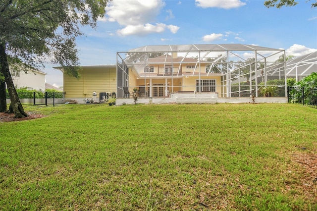 back of house with a balcony, a lanai, fence, and a lawn