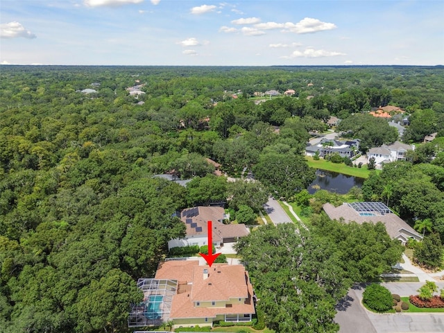 drone / aerial view featuring a forest view, a water view, and a residential view