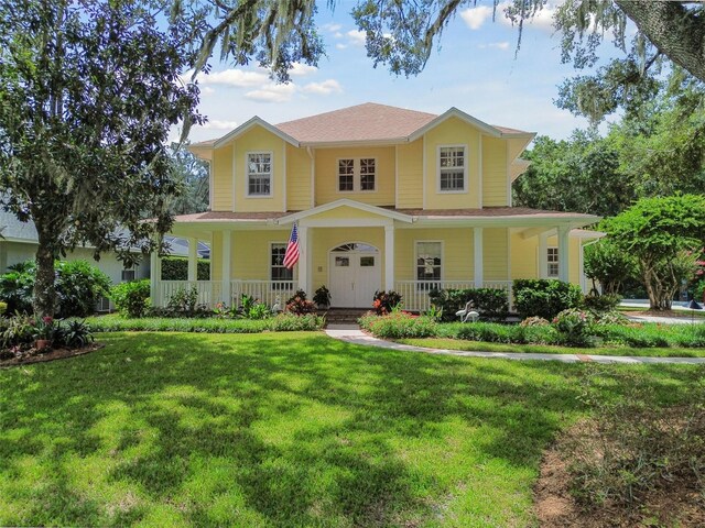 farmhouse inspired home featuring a front yard and covered porch