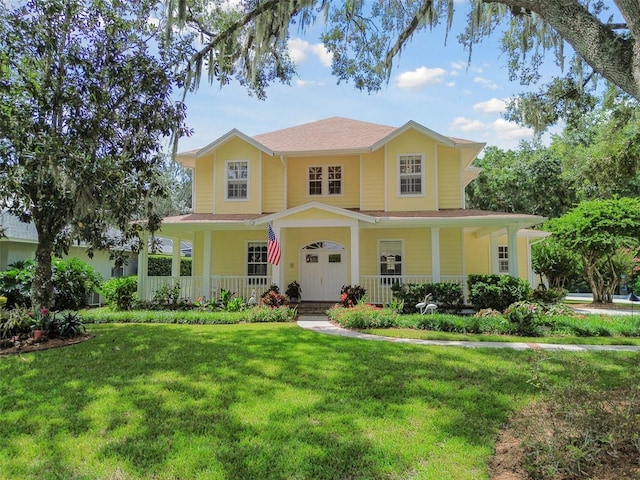 view of front of house featuring covered porch and a front lawn