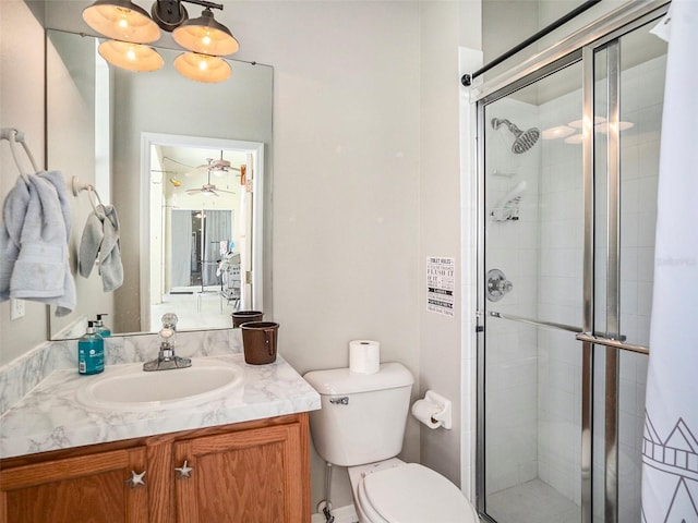 bathroom featuring a shower with shower door, toilet, and vanity