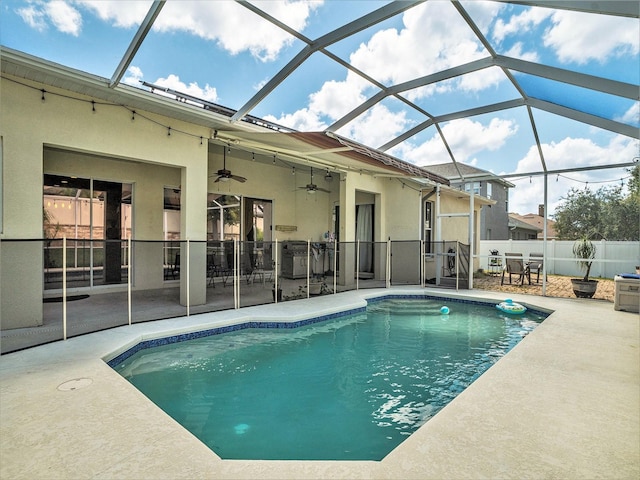 view of swimming pool featuring a lanai, ceiling fan, and a patio